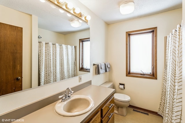 bathroom with tile patterned flooring, a shower with shower curtain, a textured ceiling, vanity, and toilet