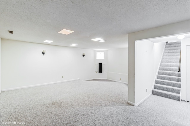 basement featuring a textured ceiling and light colored carpet