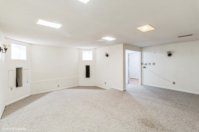 empty room with a textured ceiling and light carpet