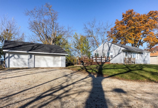 view of property exterior with a garage, a yard, and a deck