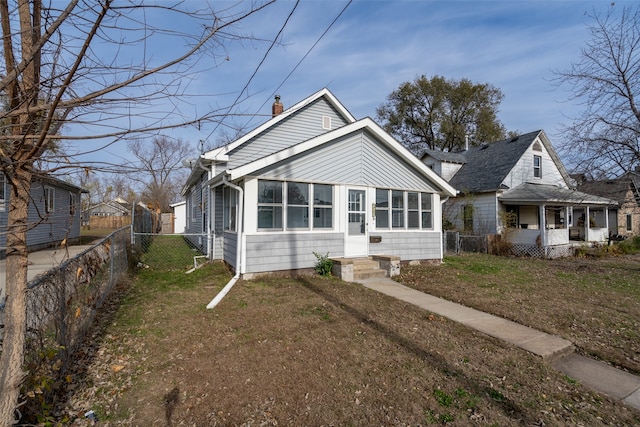 bungalow with a front yard and a sunroom