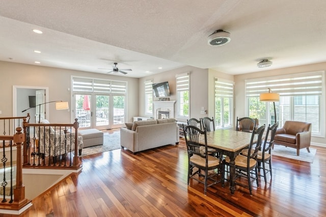 dining room featuring recessed lighting, dark wood finished floors, stairs, french doors, and a glass covered fireplace