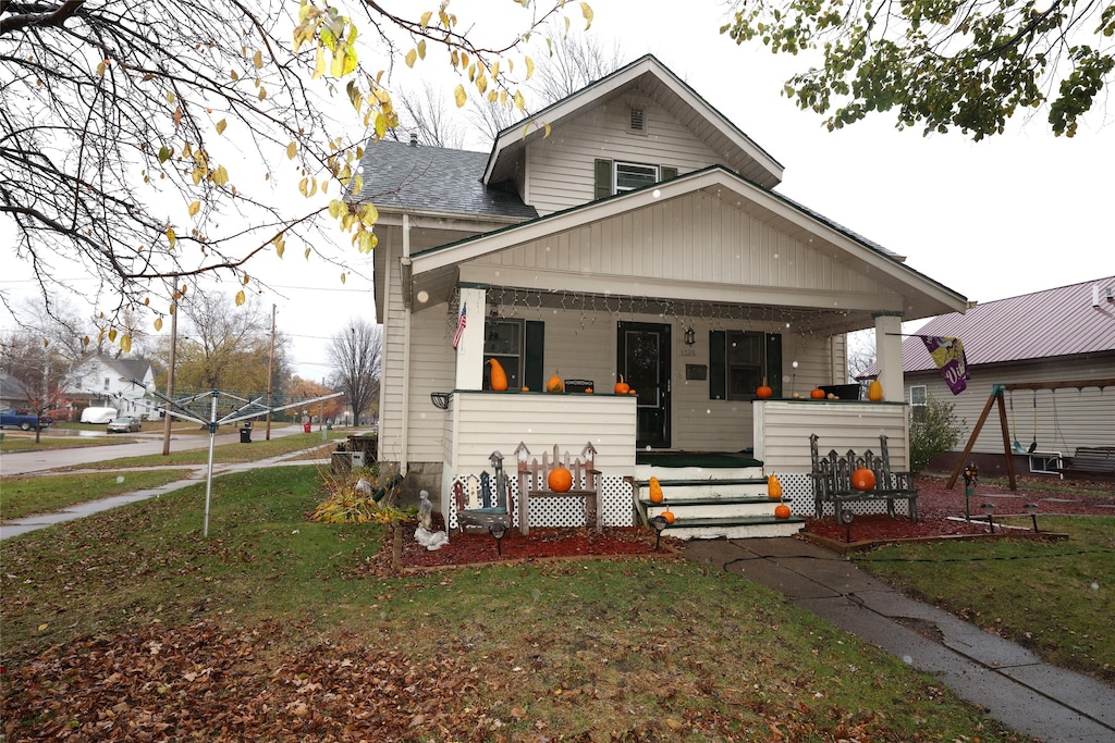 bungalow-style house featuring a porch and a front yard