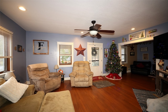 living room featuring dark wood-type flooring and ceiling fan