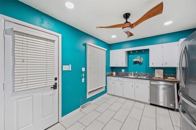 kitchen with white cabinets, stainless steel appliances, ceiling fan, and sink