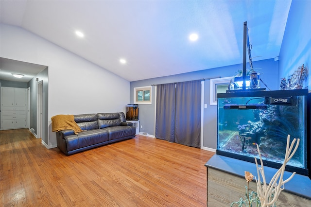 living room with hardwood / wood-style flooring and vaulted ceiling