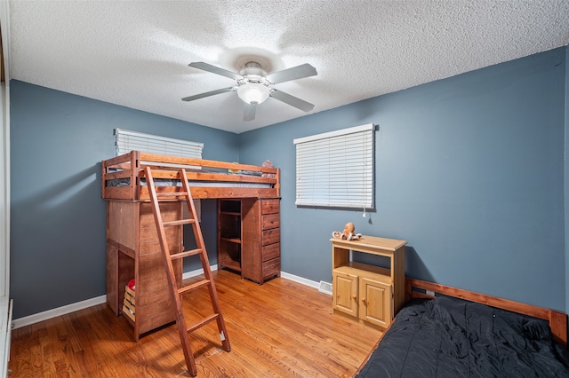 bedroom featuring a textured ceiling, light hardwood / wood-style floors, and ceiling fan