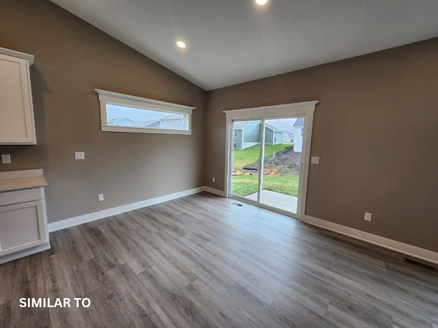 unfurnished living room featuring light wood-type flooring and lofted ceiling