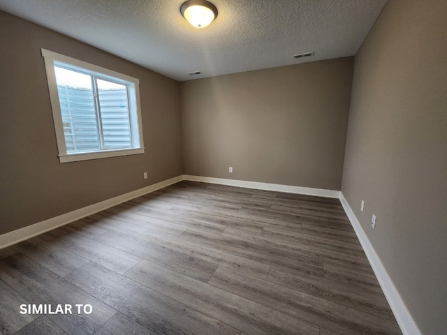 spare room with hardwood / wood-style floors and a textured ceiling