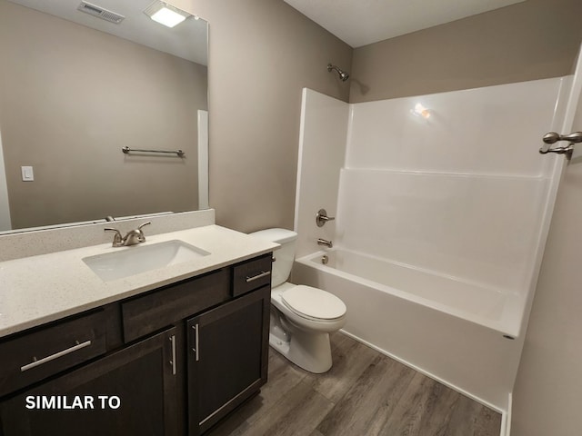 full bathroom with vanity, hardwood / wood-style flooring, toilet, and tub / shower combination