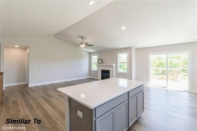 kitchen with light hardwood / wood-style floors, gray cabinets, and lofted ceiling