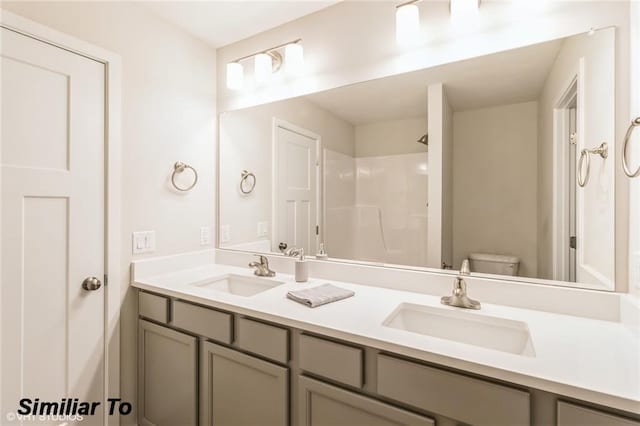 bathroom featuring vanity, toilet, and a shower