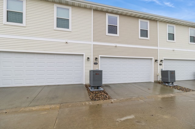 exterior space with central AC unit and a garage