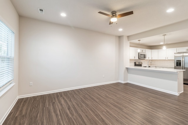 unfurnished living room with dark wood-style floors, visible vents, baseboards, and a ceiling fan