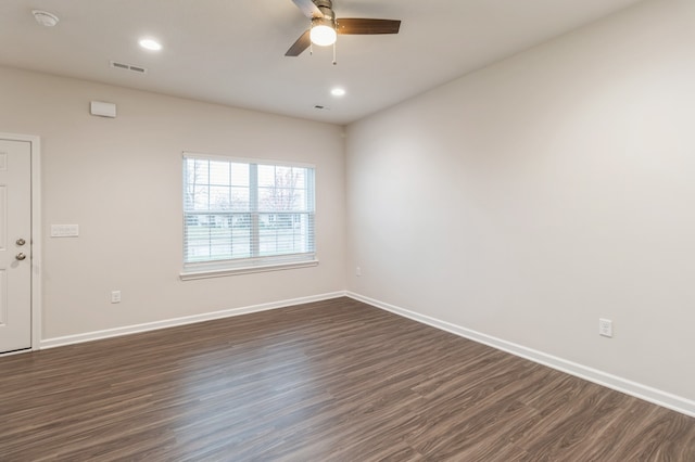 spare room featuring dark wood-style flooring, recessed lighting, visible vents, a ceiling fan, and baseboards