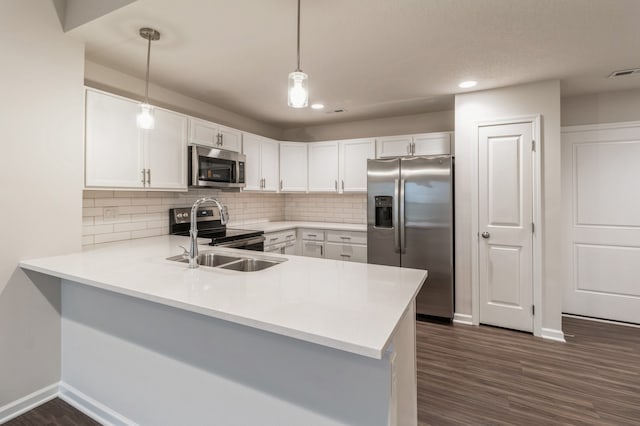 kitchen featuring a peninsula, appliances with stainless steel finishes, light countertops, and visible vents