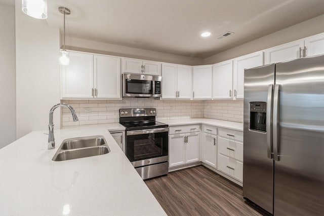 kitchen with white cabinets, appliances with stainless steel finishes, pendant lighting, and sink