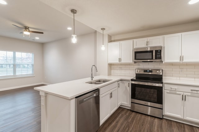 kitchen featuring decorative backsplash, dark wood-style floors, appliances with stainless steel finishes, white cabinetry, and a sink