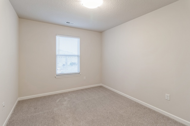 unfurnished room featuring carpet floors and a textured ceiling