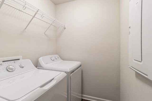 clothes washing area featuring laundry area, baseboards, and washer and dryer