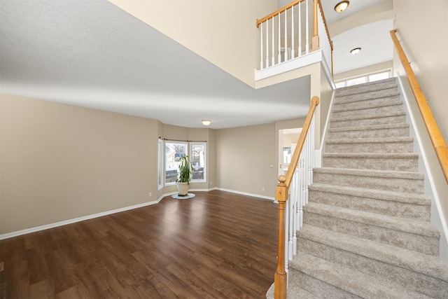 stairway with a textured ceiling and hardwood / wood-style flooring