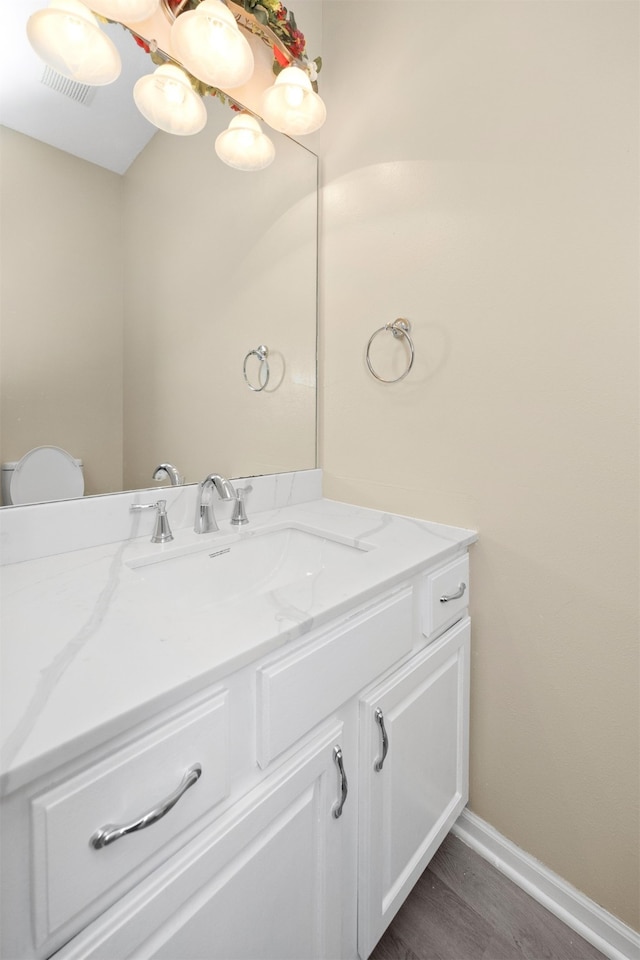 bathroom with hardwood / wood-style floors, vanity, and toilet