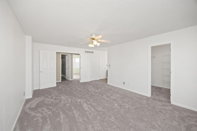 spare room with carpet flooring, ceiling fan, and a textured ceiling