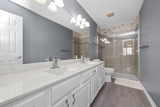 bathroom featuring vanity, wood-type flooring, an enclosed shower, and toilet