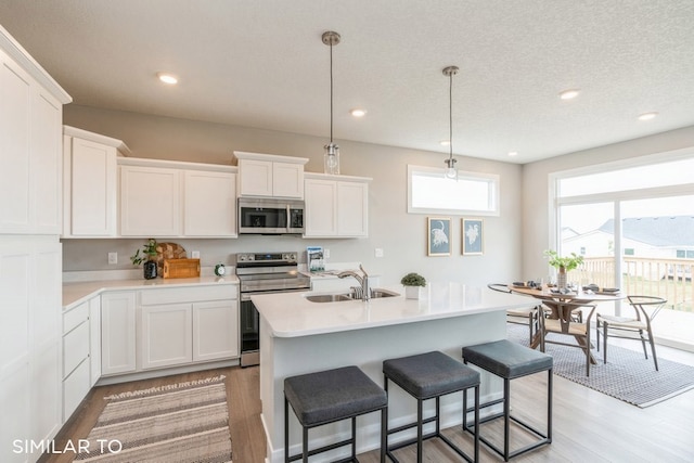 kitchen with appliances with stainless steel finishes, white cabinetry, and sink