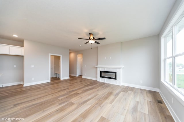 2806 22nd St SW, Altoona, IA 50009 - unfurnished living room featuring healthy amount of natural light, a ceiling fan, light wood-type flooring, recessed lighting, and a glass covered fireplace