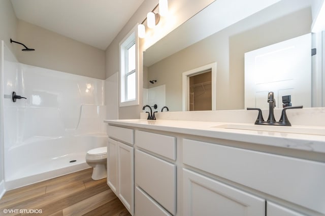 2806 22nd St SW, Altoona, IA 50009 - bathroom with a shower, wood finished floors, toilet, and double vanity