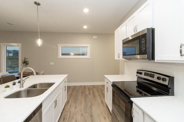 kitchen with white cabinetry, sink, pendant lighting, and appliances with stainless steel finishes