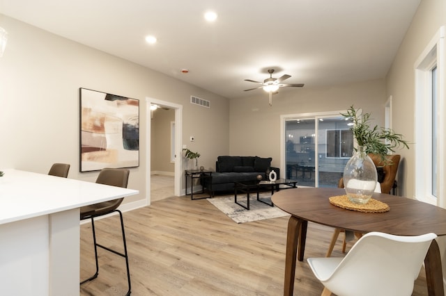 dining room with ceiling fan and light hardwood / wood-style flooring