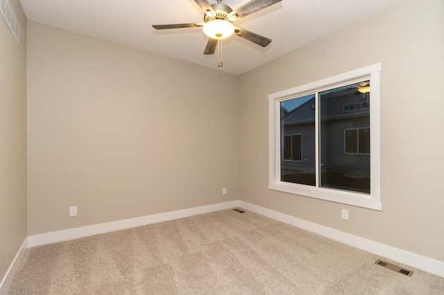 spare room featuring ceiling fan and light colored carpet