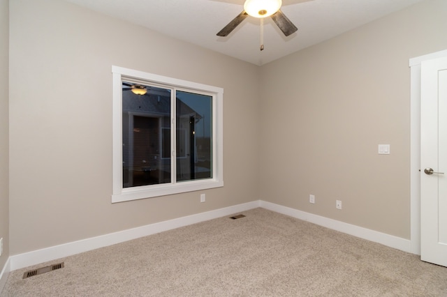 empty room with ceiling fan and light carpet