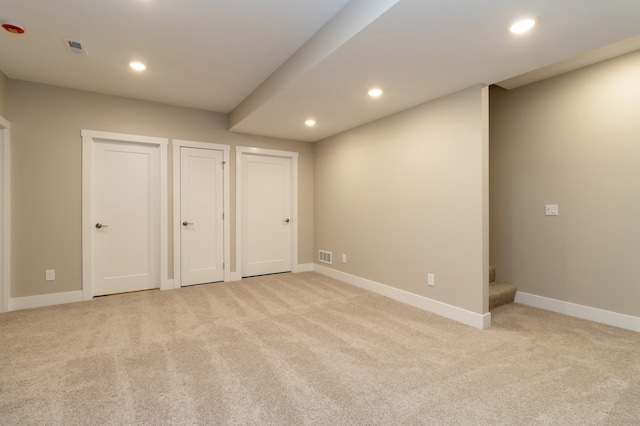 unfurnished bedroom with light colored carpet and two closets