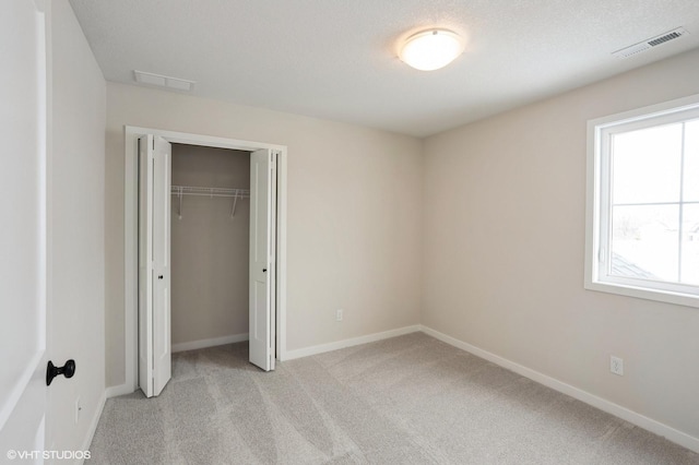 unfurnished bedroom with light colored carpet, visible vents, and baseboards