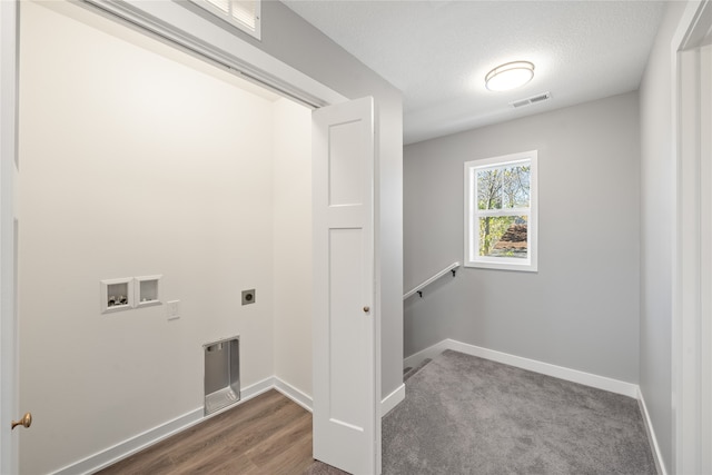 washroom with electric dryer hookup, hookup for a washing machine, dark hardwood / wood-style floors, and a textured ceiling