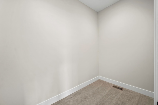 spare room featuring light colored carpet