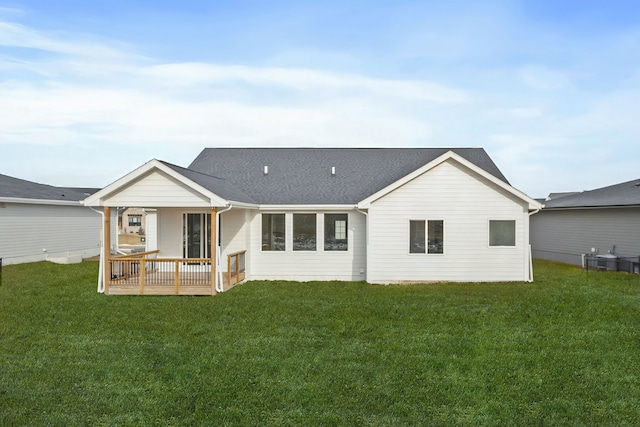 rear view of house with central AC unit, a yard, and a deck