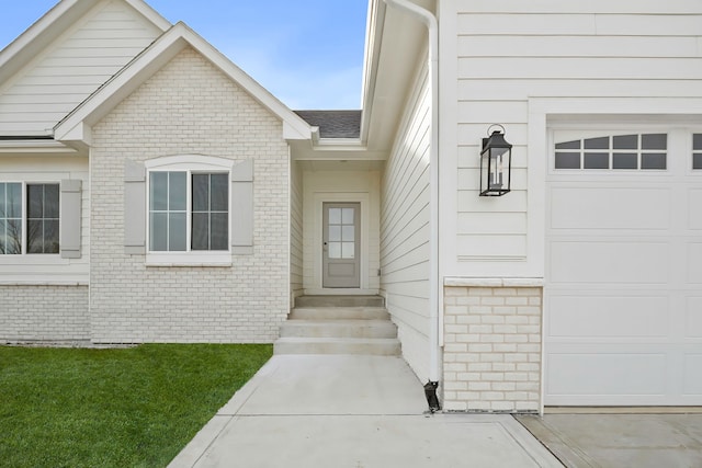 doorway to property featuring a garage and a yard