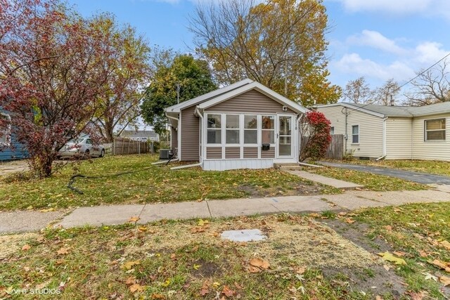 bungalow-style home featuring central AC unit and a sunroom