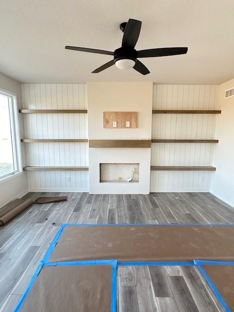 unfurnished living room with hardwood / wood-style flooring and ceiling fan