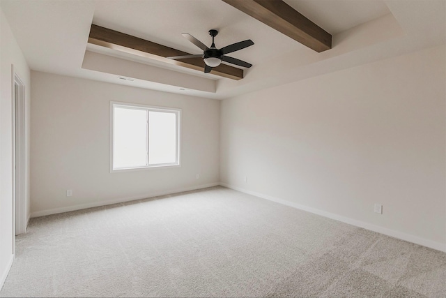 unfurnished room featuring a tray ceiling, carpet flooring, and beam ceiling