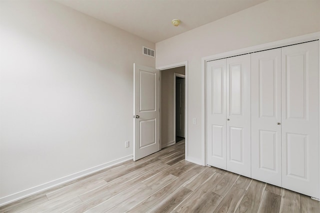 unfurnished bedroom with a closet and light hardwood / wood-style flooring