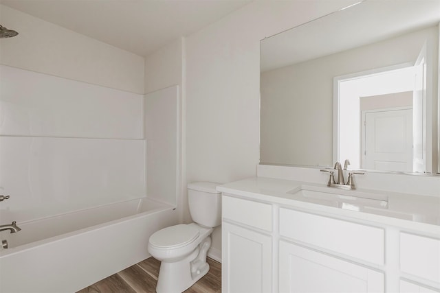 full bathroom featuring wood-type flooring, toilet, bathing tub / shower combination, and vanity