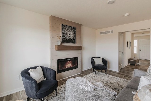 living room with dark wood-type flooring and a fireplace