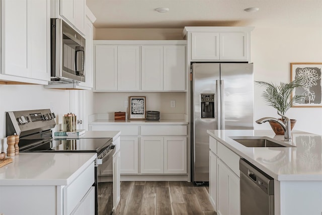 kitchen featuring sink, stainless steel appliances, white cabinets, and light wood-type flooring