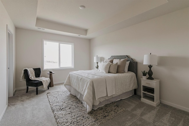 bedroom with a tray ceiling and carpet flooring