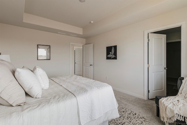 bedroom with a tray ceiling and carpet